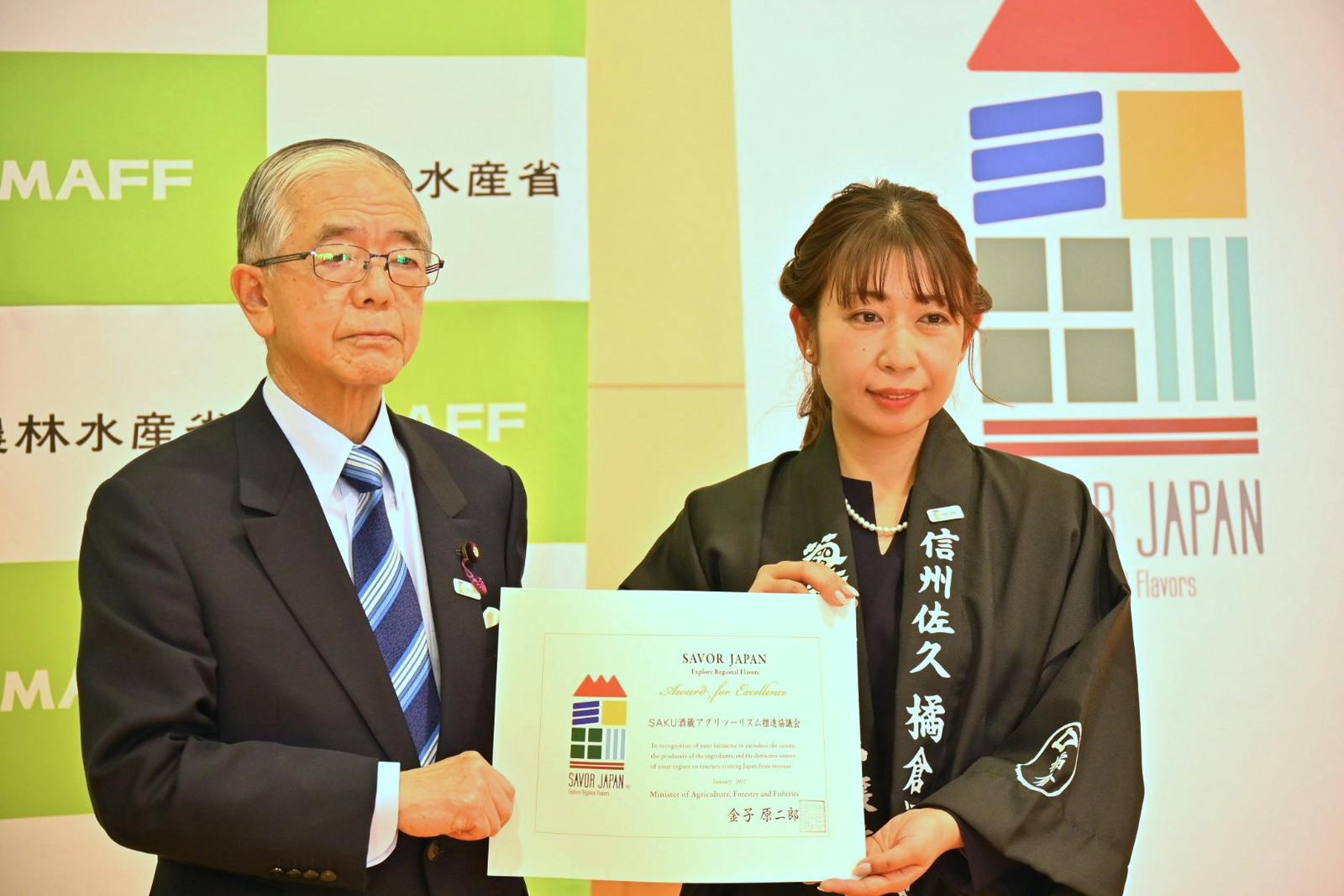 ▲「SAVOR JAPAN」の認定証授与の様子、金子農林水産大臣（右）田澤麻里香氏（左）