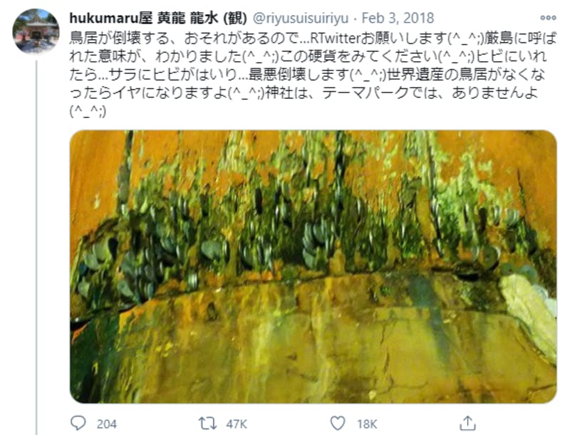 Twitterに投稿された、厳島神社の大鳥居の溝に硬貨が差し込まれている様子